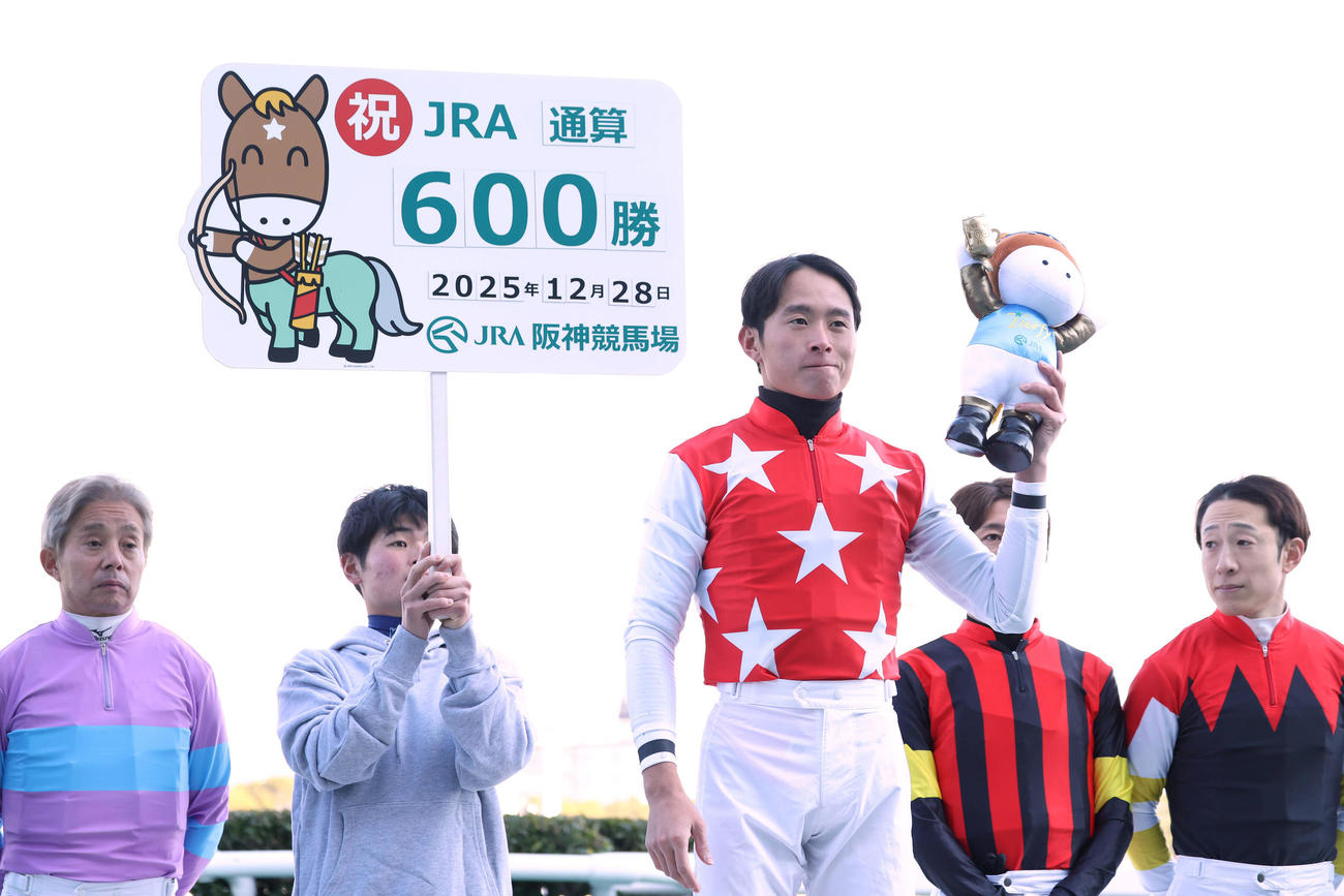JRA通算600勝を達成してガッツポーズで記念写真に納まる岩田望騎手（中央）（撮影・白石智彦）