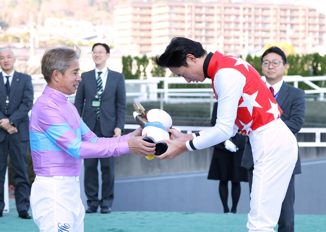 JRA通算600勝を達成して父の岩田康騎手（左）から記念のターフィー人形を授与される岩田望騎手（撮影・白石智彦）