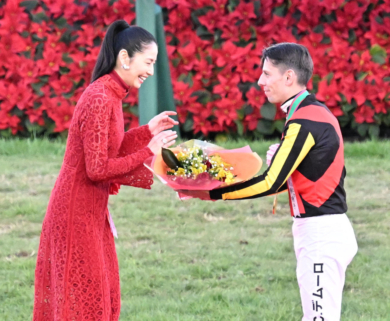 プレゼンターを務めた長澤まさみから受け取った花束をプレゼントするC・デムーロ騎手（撮影・千葉一成）