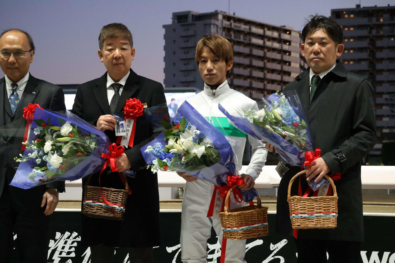 川崎11R・川崎マイラーズ（S3）　左海誠二騎手との記念写真を手に川崎マイラーズの表彰式で記念撮影に納まる林正人調教師（左から2人目）＝2026年1月3日