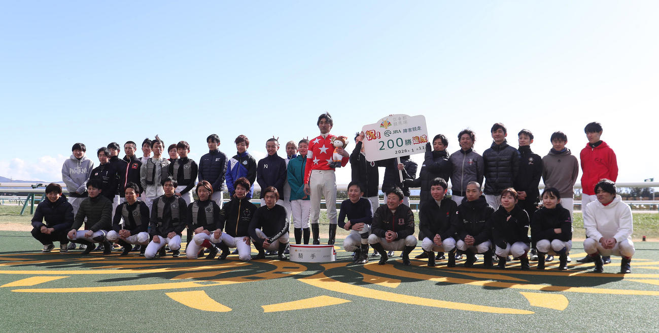 京都4R、JRA障害競走通算200勝を達成して騎手仲間と記念写真に納まる西谷騎手（中央）（撮影・白石智彦）