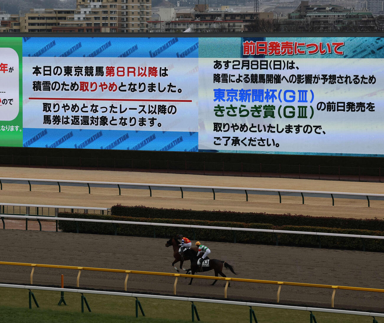 東京8R以降の取りやめを告げるターフビジョンと引き揚げる各馬（撮影・丹羽敏通）
