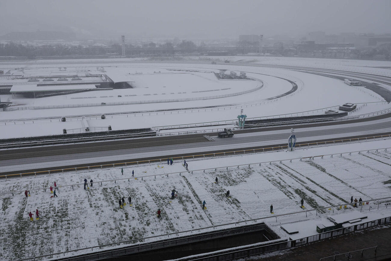 雪のため開催中止が発表された東京競馬場。芝コースでは、人海戦術の除雪作業が始まった（撮影・丹羽敏通）