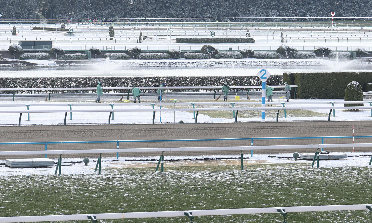 障害コースを除雪する作業員（撮影・白石智彦）