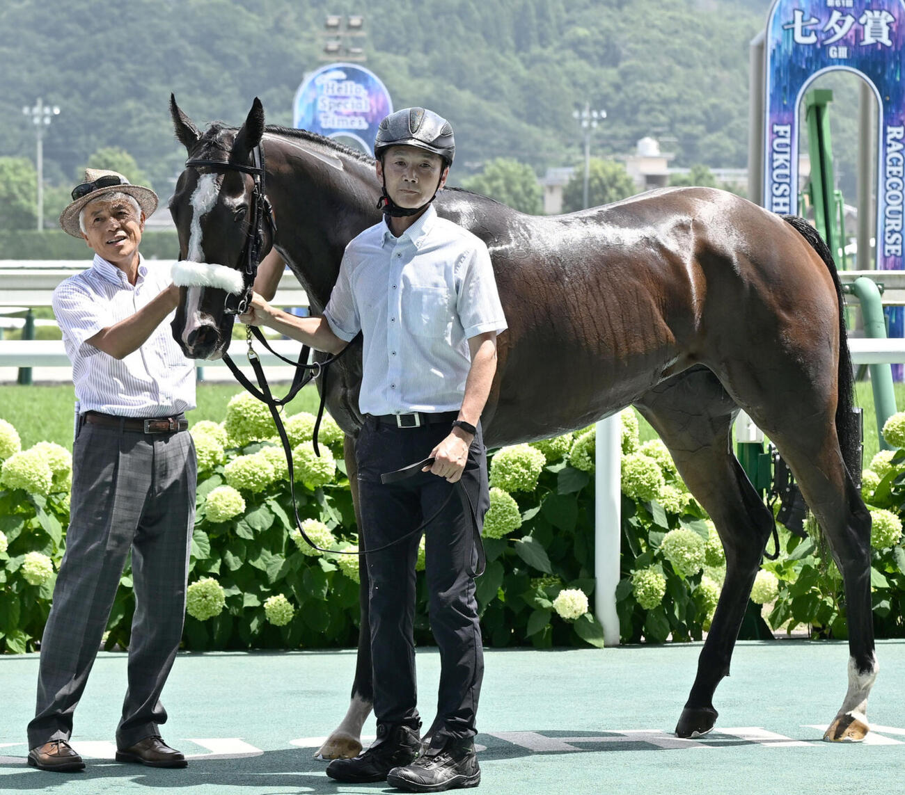 25年7月、2歳新馬戦を制したルージュボヤージュの口取りをする国枝師（左）