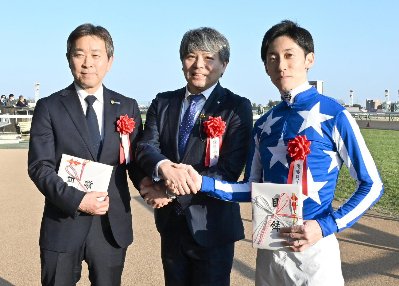 東京11R、共同通信杯をリアライズシリウスで制し、写真撮影に応じる、左から手塚師、馬主の今福氏、津村騎手（2026年2月15日撮影）