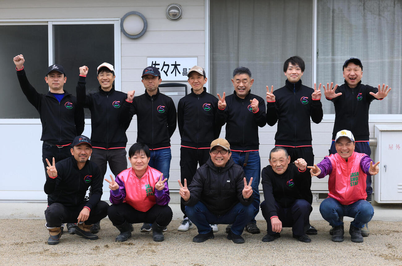 26日、厩舎スタッフと記念撮影する佐々木調教師（前列左から3人目）