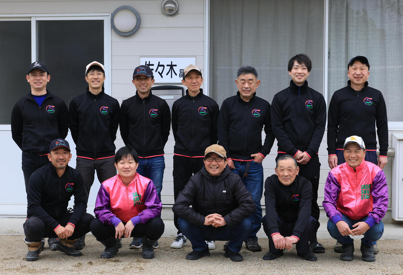 26日、厩舎スタッフと記念撮影する佐々木調教師（前列左から3人目）