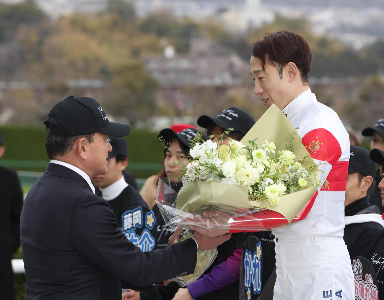 父の藤岡師（左）から花束を贈呈される藤岡佑介騎手（撮影・白石智彦）