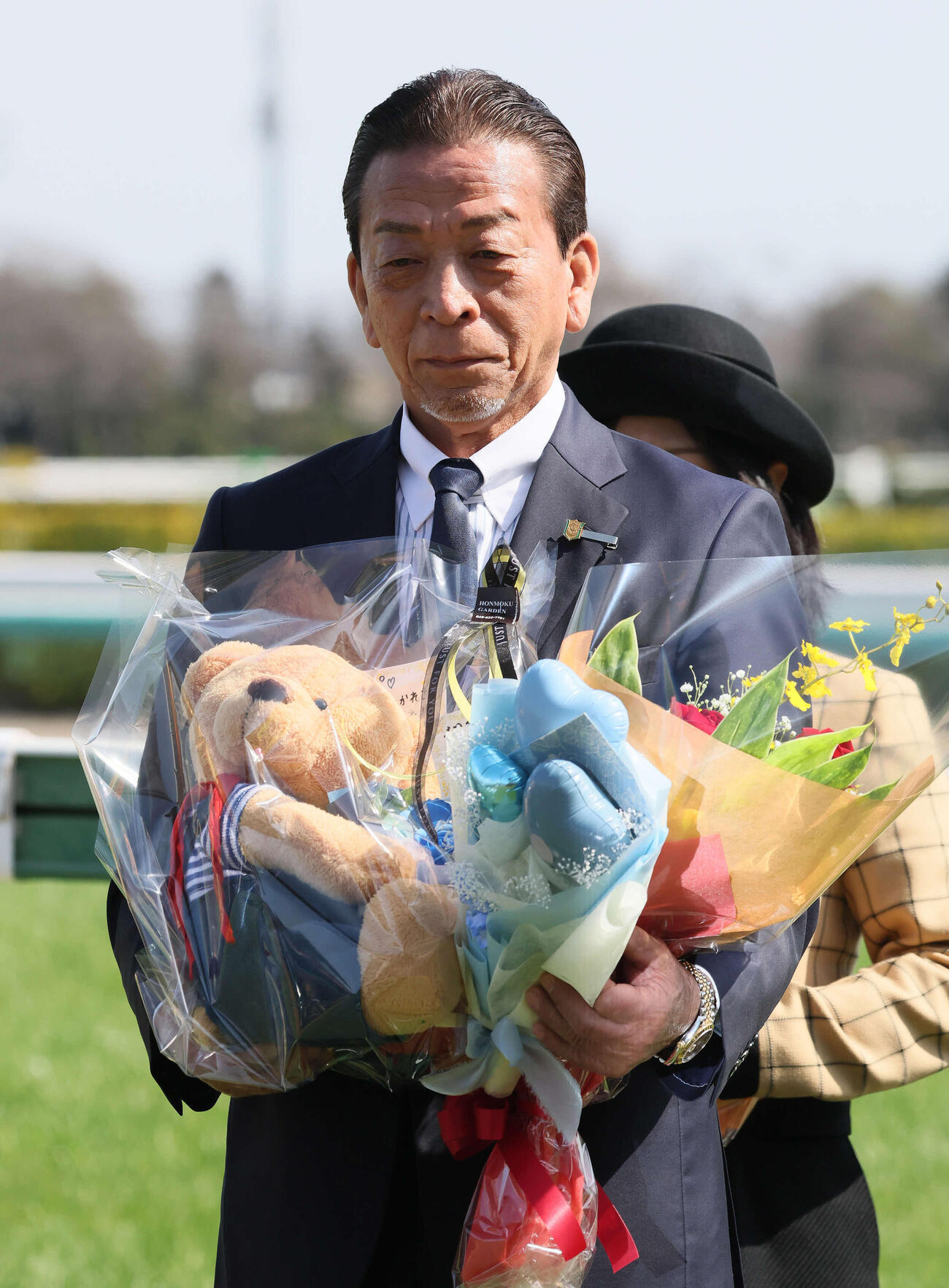 花束を手に写真に納まる土田師（撮影・丹羽敏通）