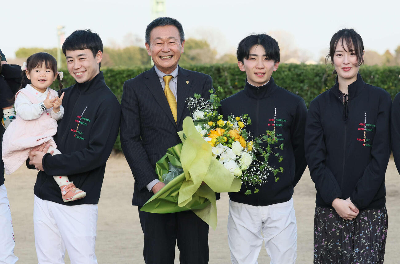 花束を手に弟子の、左から野中騎手。1人おいて長浜騎手、藤田さんと写真に納まる根本師（撮影・丹羽敏通）
