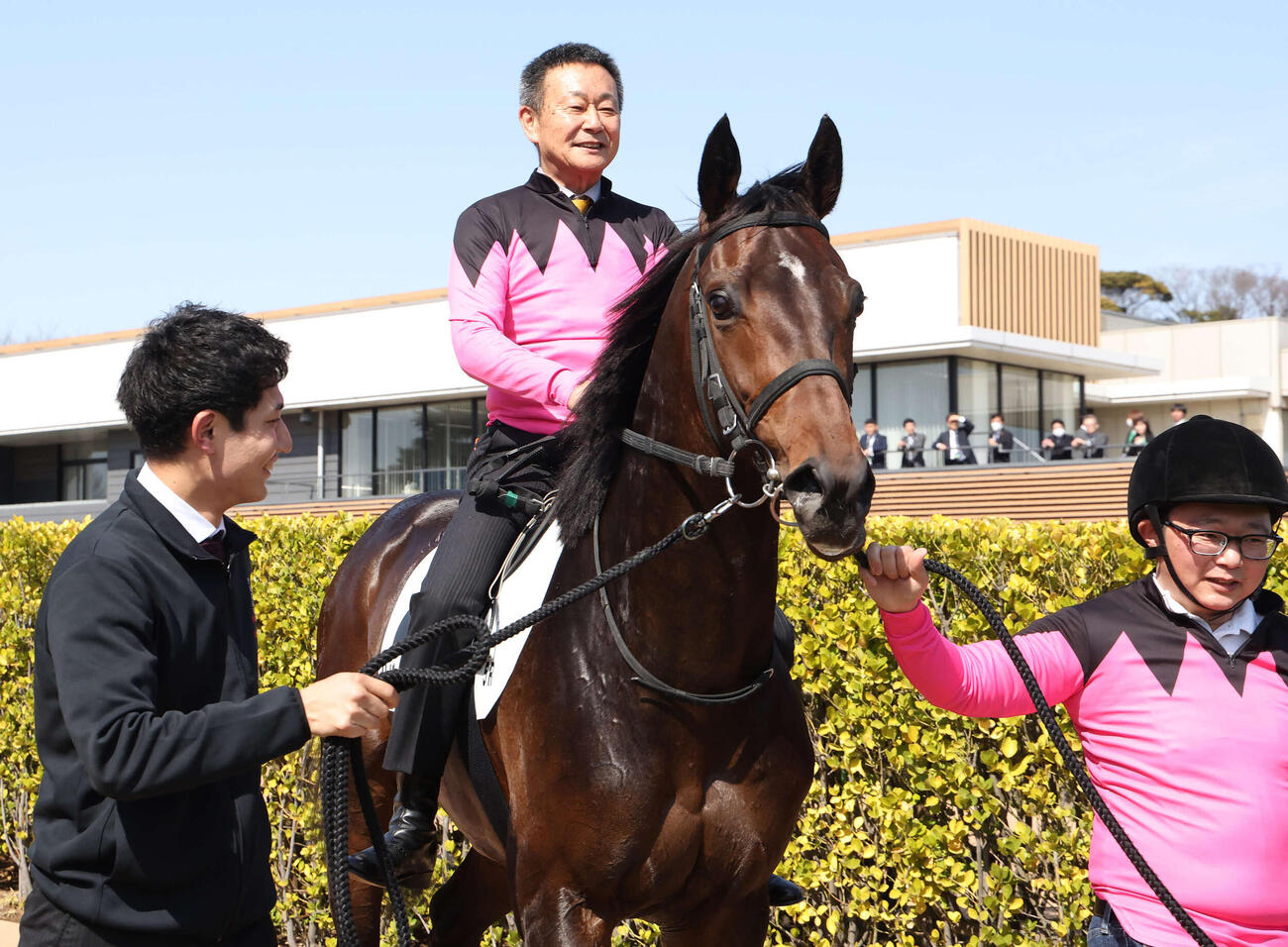 中山5R、3歳未勝利戦を制したサザンテイオーにまたがって口取りに向かう根本師（撮影・丹羽敏通）