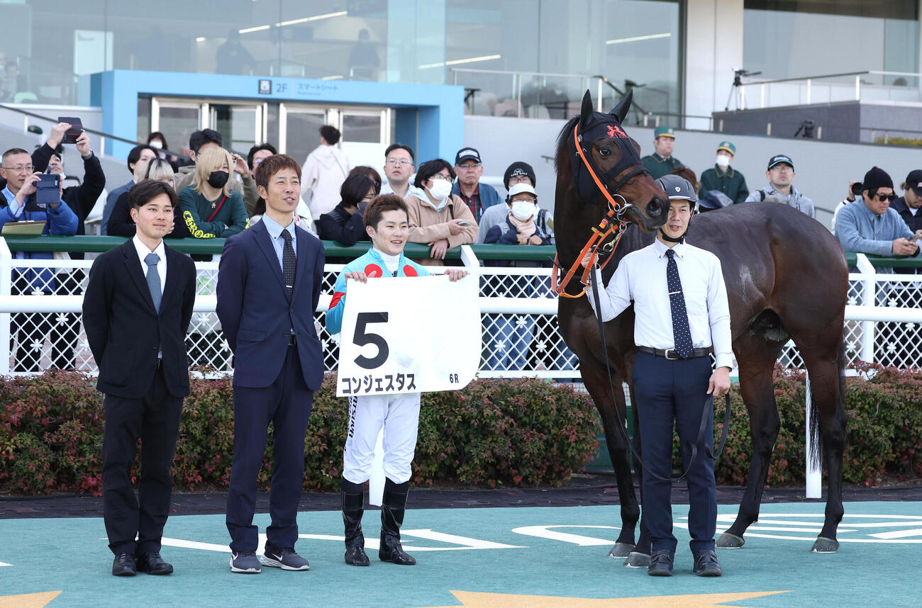 阪神6R、3歳1勝クラスを制したコンジェスタスと口取りに並ぶ西村淳騎手（右から2人目）（撮影・白石智彦）