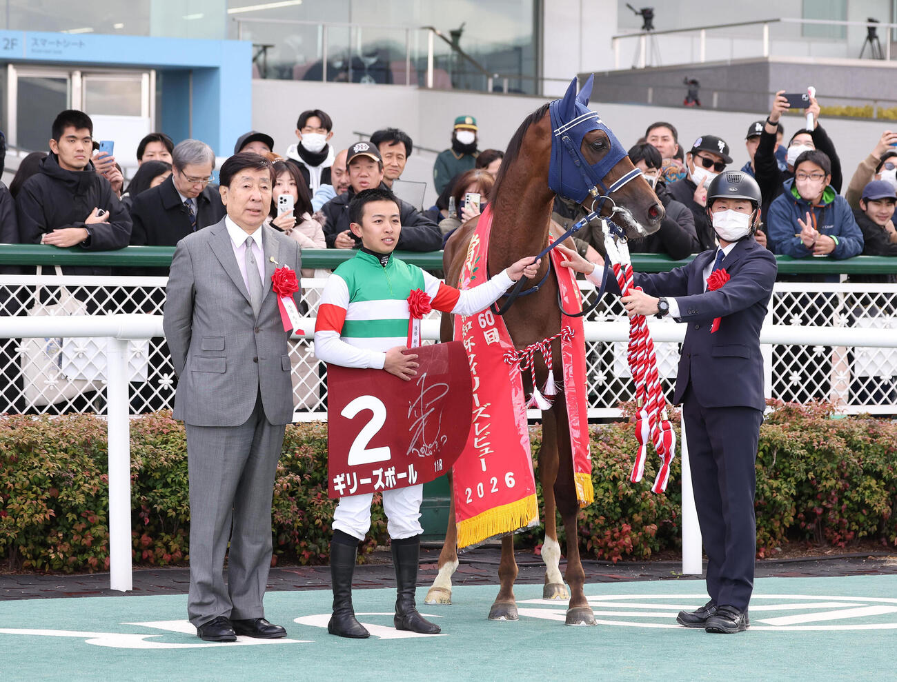 フィリーズレビューを制したギリーズボールと口取りに並ぶ西塚騎手（中央）（撮影・白石智彦）