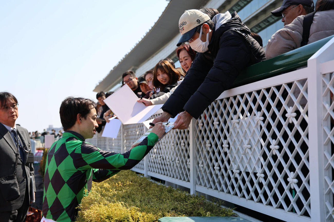 阪神4R、3歳未勝利戦をポッドリプルで制した松山騎手は通算1400勝となり、ファンにサイン（撮影・西尾就之）