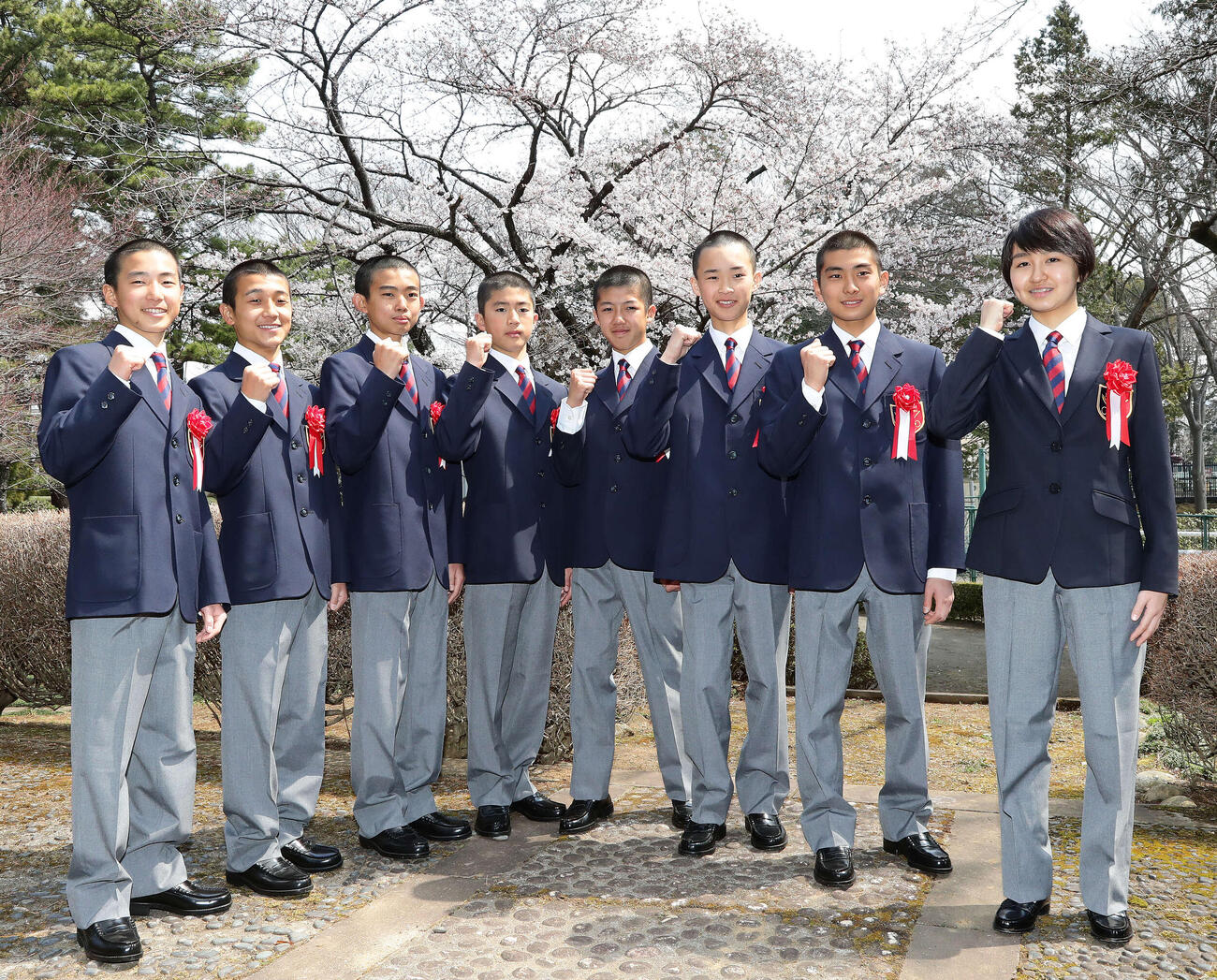 17年、競馬学校入学式後に満開の桜の前でガッツポーズを決める36期生の、左から秋山稔樹、池田遥稀、泉谷楓真、岡﨑翔優、小林脩斗、角田大和、原優介、古川奈穂