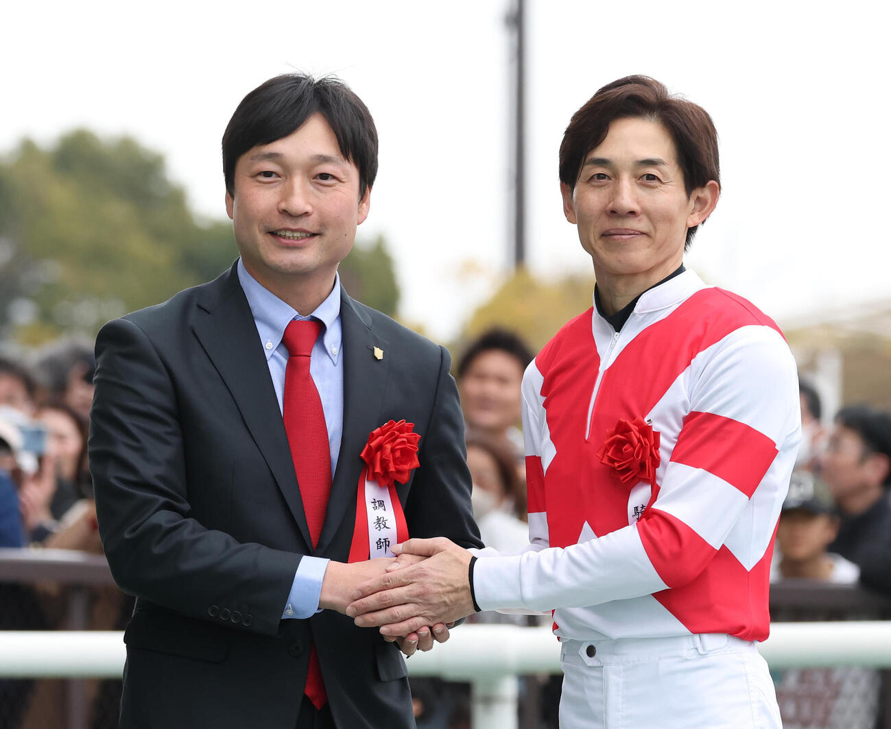 握手するアイサンサンで重賞初制覇の橋田師（左）と重賞50勝を達成した幸騎手（撮影・白石智彦）