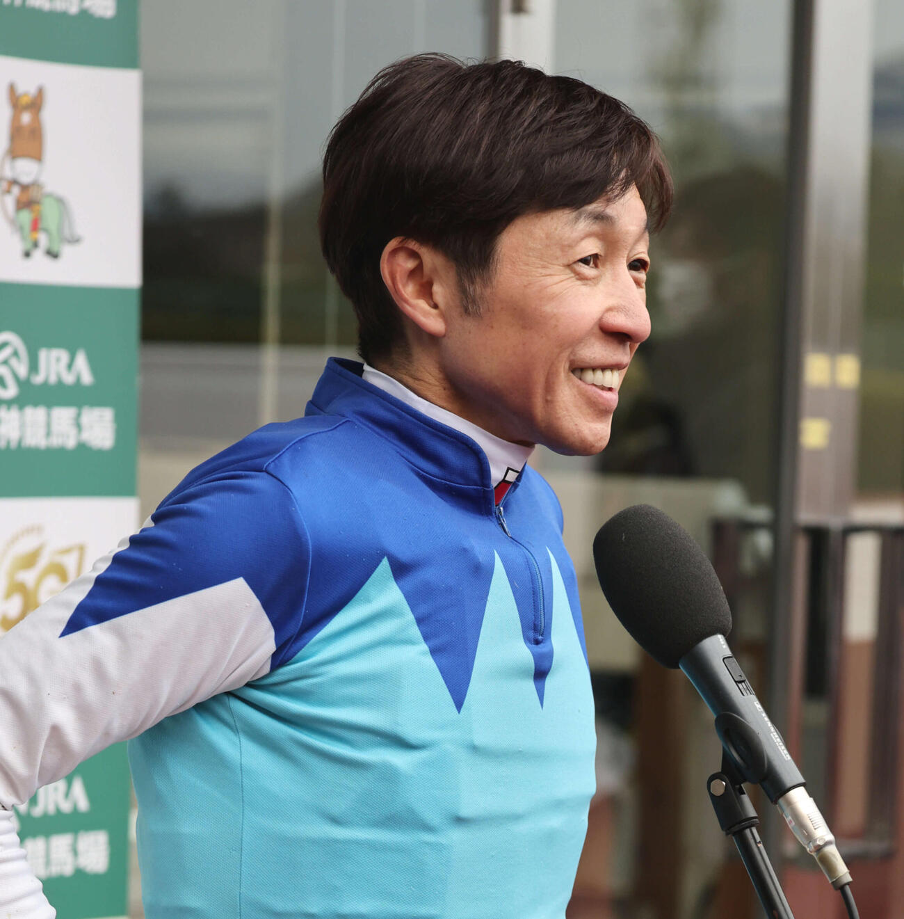 阪神大賞典をアドマイヤテラで制した武豊騎手はインタビューで笑顔を見せる（撮影・西尾就之）