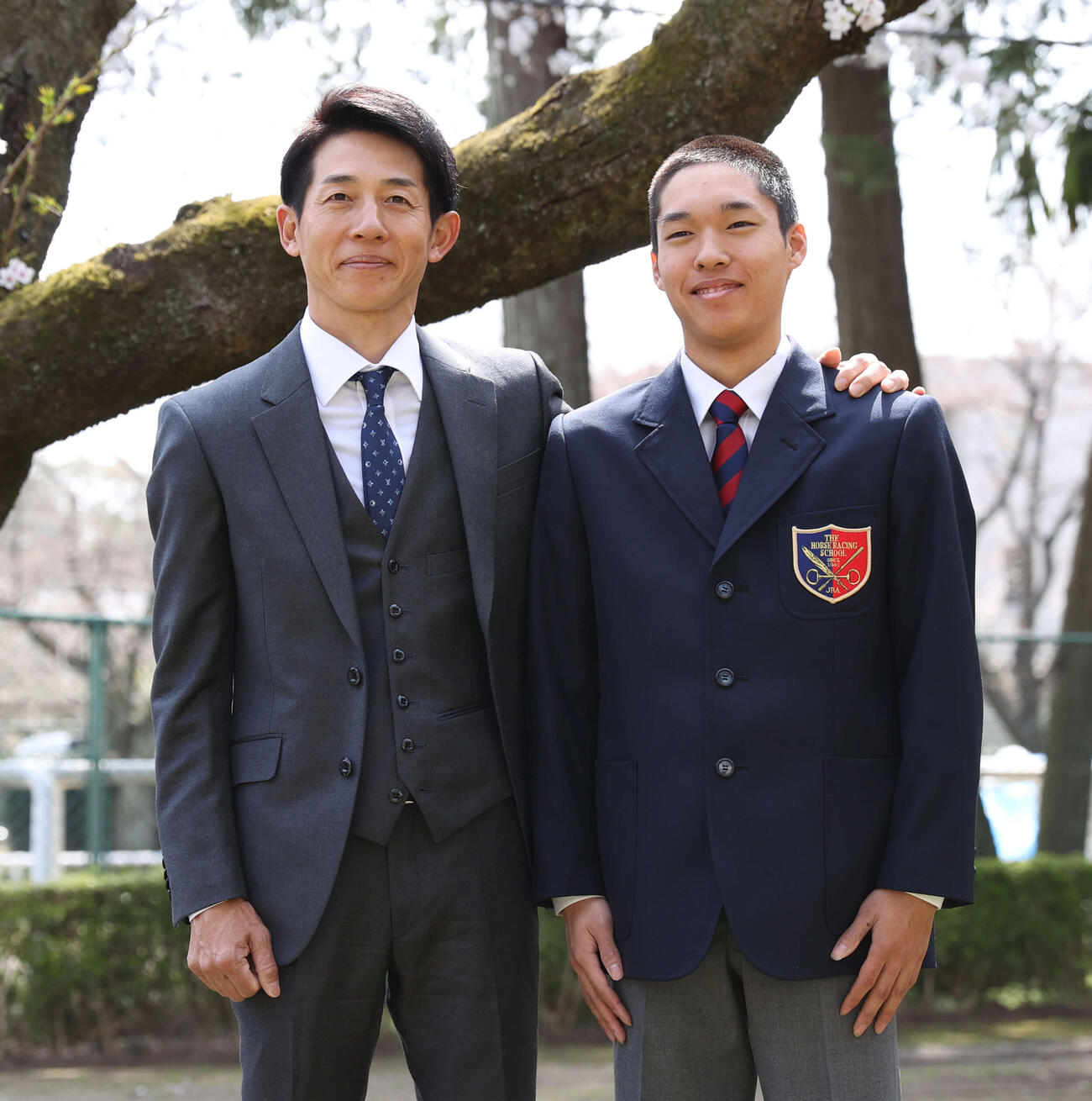24年、JRA競馬学校入学式で桜をバックに記念撮影する幸英明騎手（左）と長男大斗君