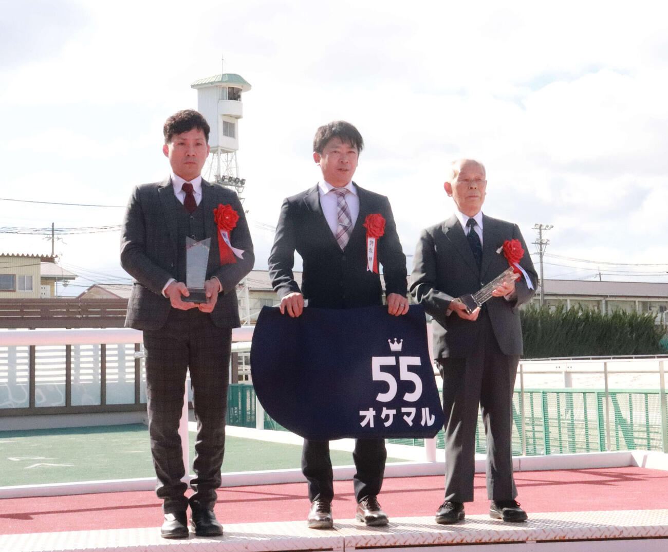 年度代表馬に選ばれたオケマルの関係者。（左から）南部真吾厩務員、盛本信春調教師、高橋文男オーナー