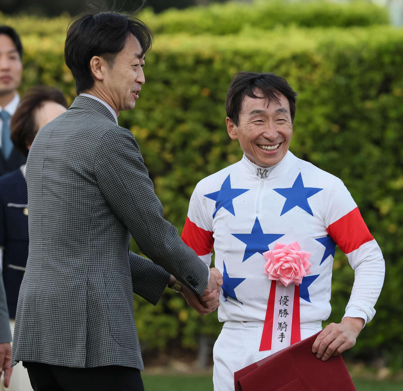 日経賞をマイユニバースで制して武幸師（左）と握手する横山典騎手（撮影・丹羽敏通）