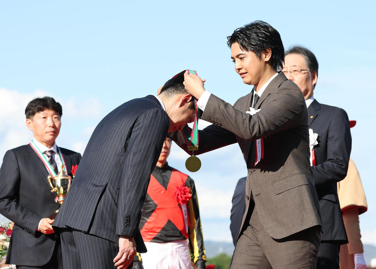 斉藤崇師（左）にメダルをかけるプレゼンターの片寄涼太