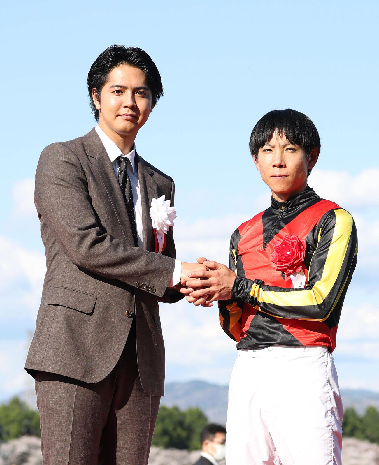 プレゼンターの片寄涼太（左）と握手する北村友騎手