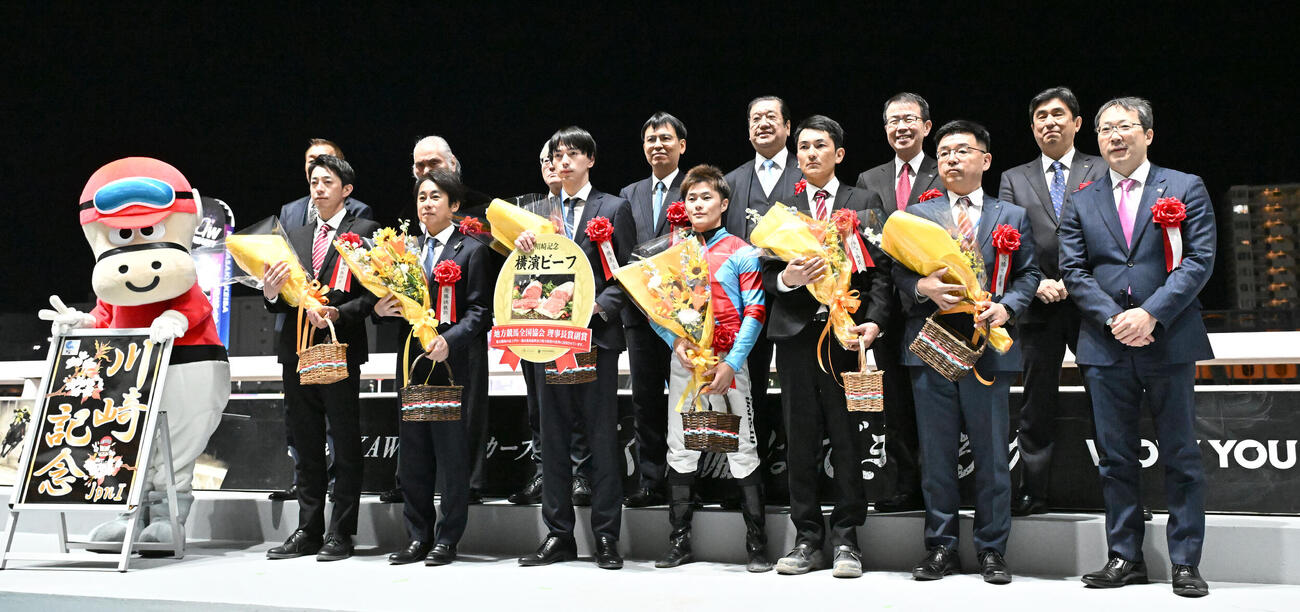 第75回川崎記念をカゼノランナーで制し、記念撮影する西村淳騎手と松永師（前列左から2人目）ら関係者