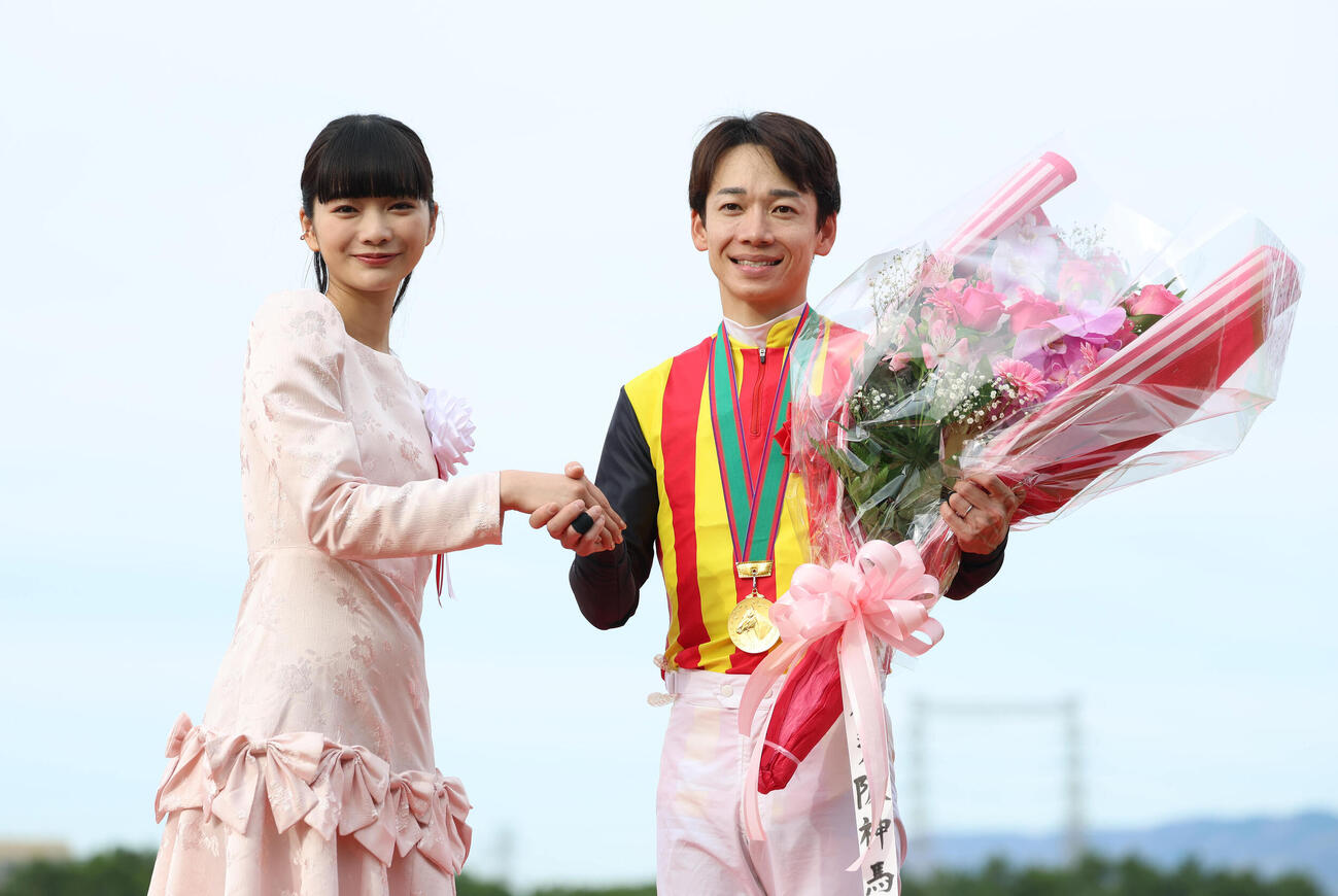 プレゼンターの見上愛（左）と握手する松山騎手（撮影・白石智彦）