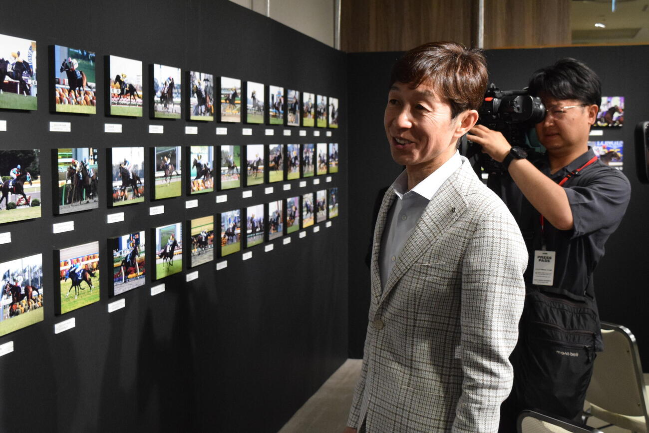 展示されたJRA・G1全優勝記念パネルを見学する武豊騎手