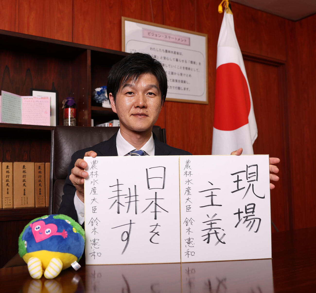座右の銘を記した色紙を手にする鈴木憲和農林水産大臣（撮影・野上伸悟）
