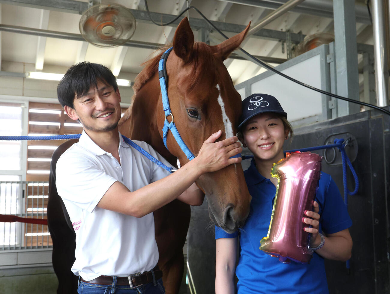 凱旋した今村聖奈騎手と記念写真に納まるジュウリョクピエロと担当の佐々木邦幸調教助手（左）