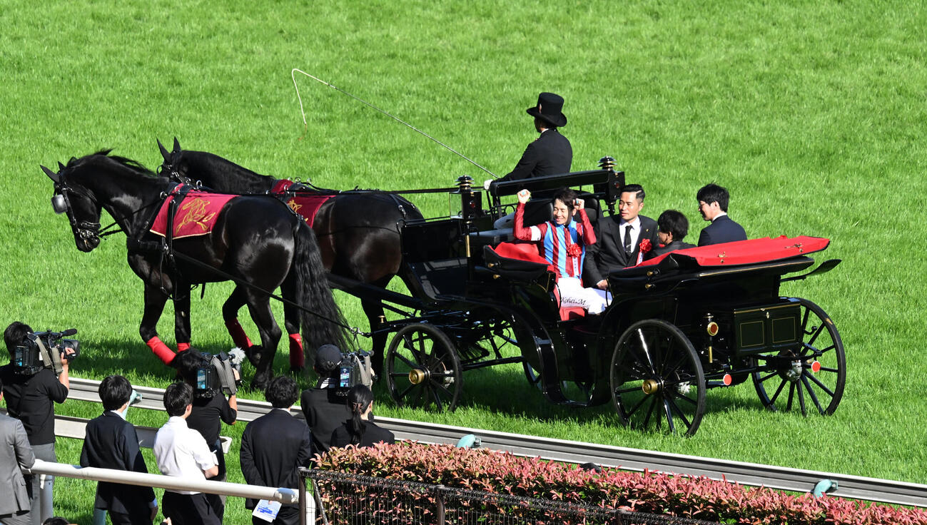 ダービーをロブチェンで制し、馬車パレードでガッツポーズする松山弘平騎手（撮影・千葉一成）