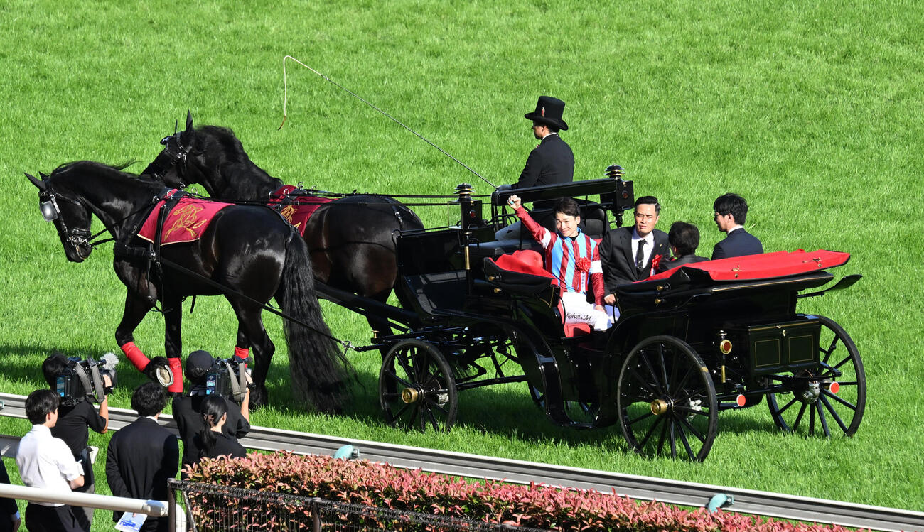 第93回日本ダービーをロブチェンで制し、馬車パレードでガッツポーズする松山弘平騎手（撮影・千葉一成）