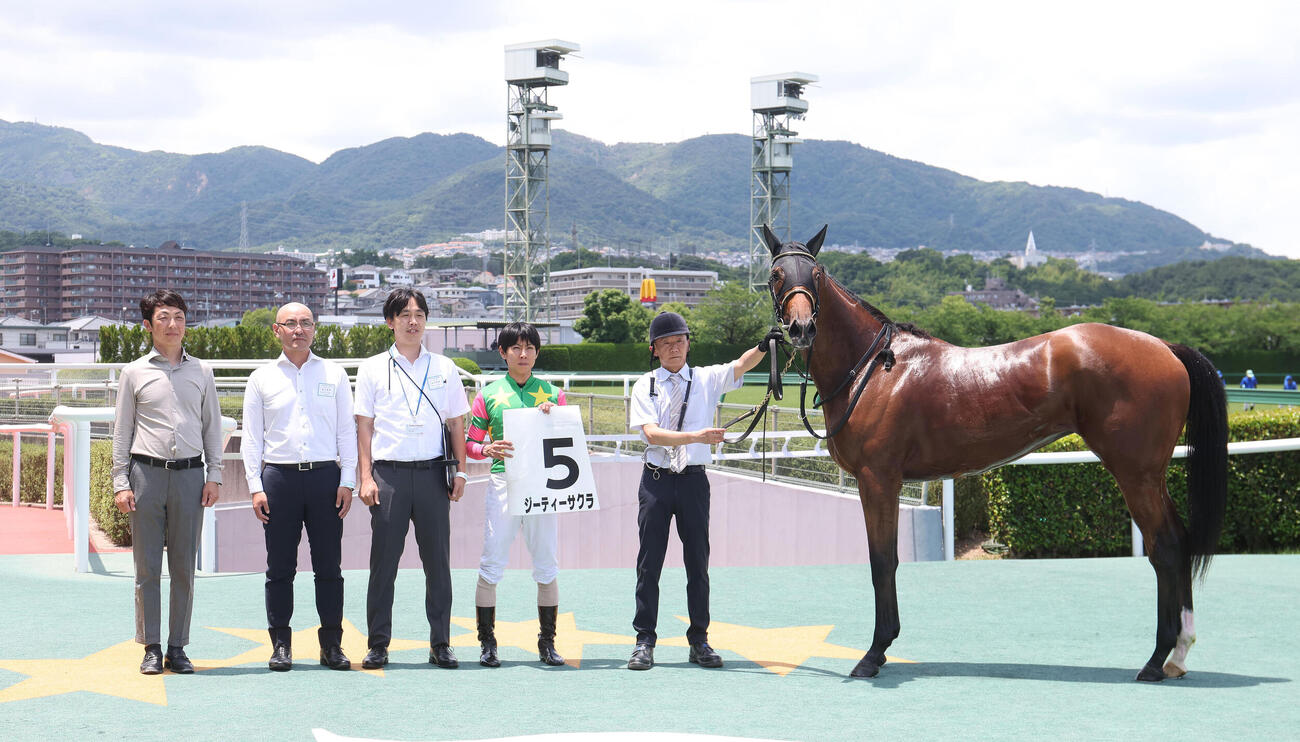 阪神5R、新馬戦を快勝したジーティーサクラと口取りに並ぶ北村友一騎手（右から2人目）（撮影・白石智彦）