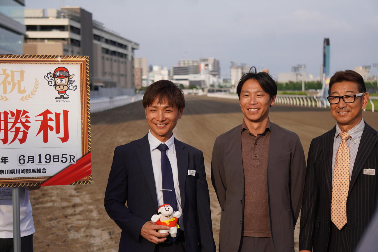 川崎5Rをアイビーブリッツで勝利し、開業初勝利を挙げた山崎誠士調教師（左）と兄の裕也師（中央）、父の尋美師（右）