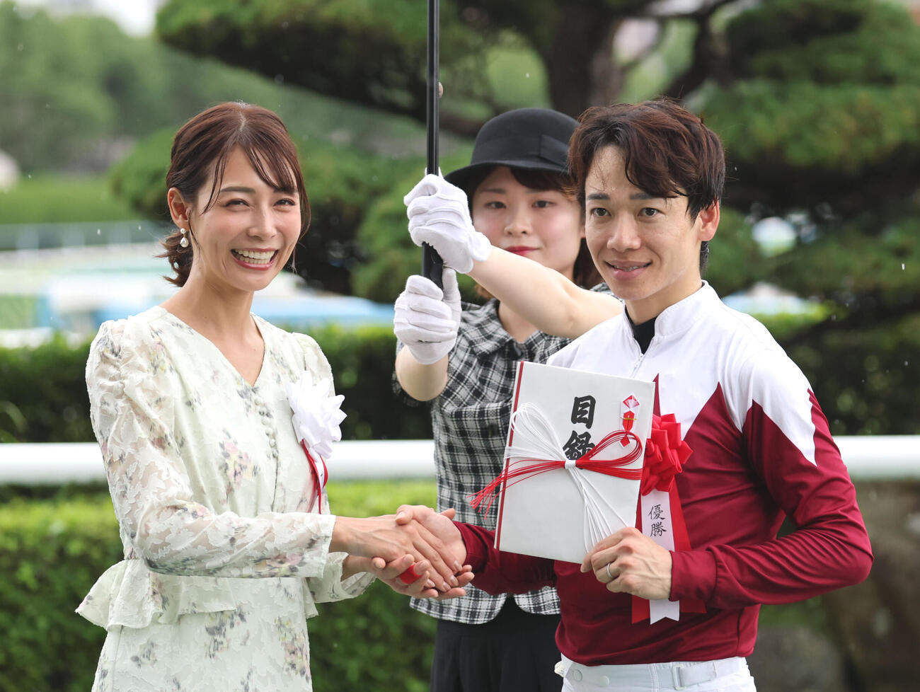 北九州記念を制した松山弘平騎手と握手するプレゼンターの相武紗季（撮影・梅根麻紀）