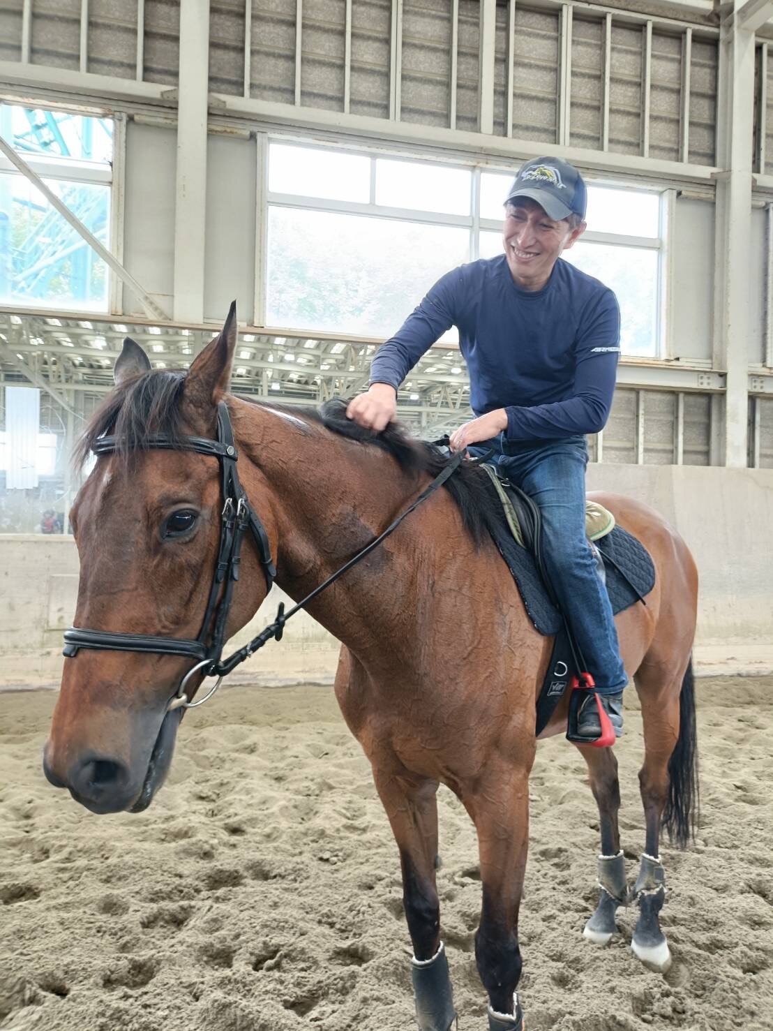 函館競馬場で誘導馬として活躍するクリンチャーと再会し、またがった長谷川万人助手（写真は本人提供）
