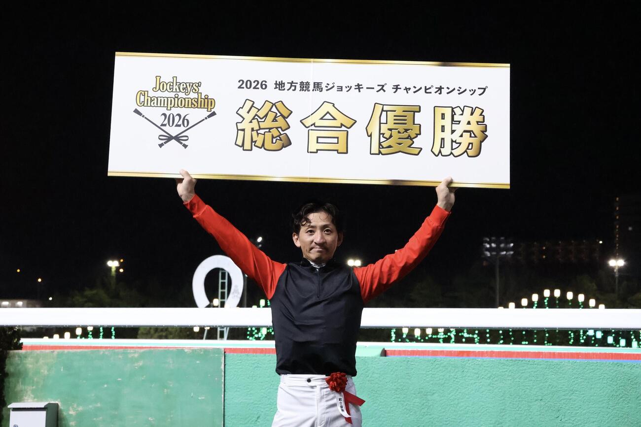 地方競馬ジョッキーズCSで総合優勝を果たしボードを掲げる兵庫の吉村智洋騎手(2026年6月撮影)