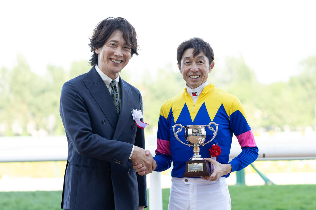 ゲストプレゼンターの佐々木蔵之介と握手する武豊騎手