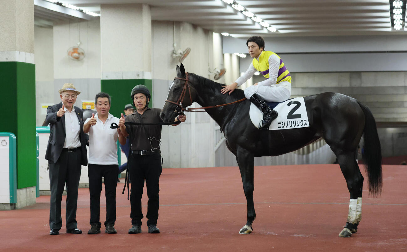 新潟3R、2歳未勝利戦を制したニシノリリックスの口取りでポーズを決める小野次郎調教師と馬上の石橋脩騎手（撮影・丹羽敏通）