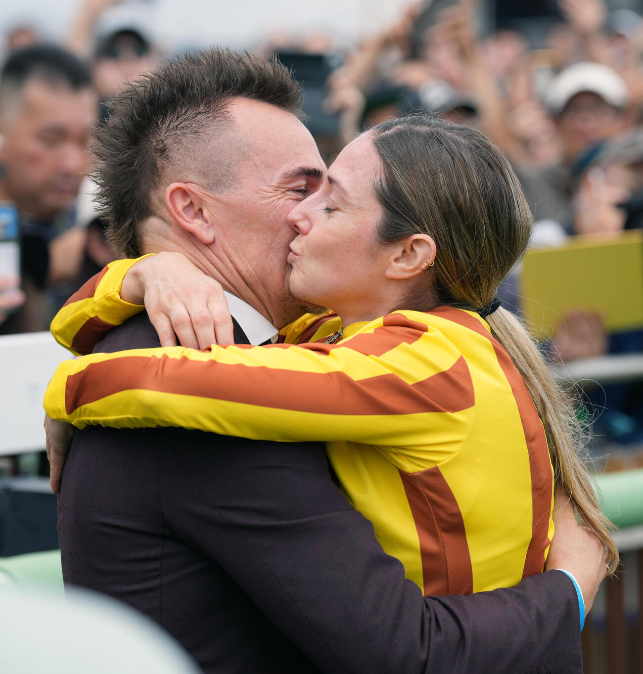 中山5R、2歳新馬戦を制し夫のフレデリック・スパニュ氏（左）とキスを交わすミカエル・ミシェル騎手（撮影・小島史椰）