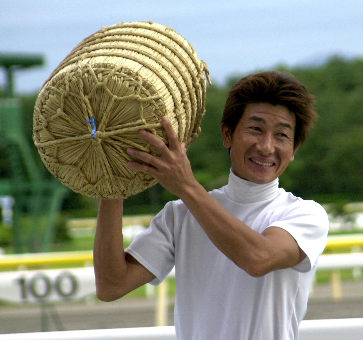 03年9月7日、新潟競馬リーデングジョッキーに輝き米俵を担ぎ、にっこりする柴田善騎手