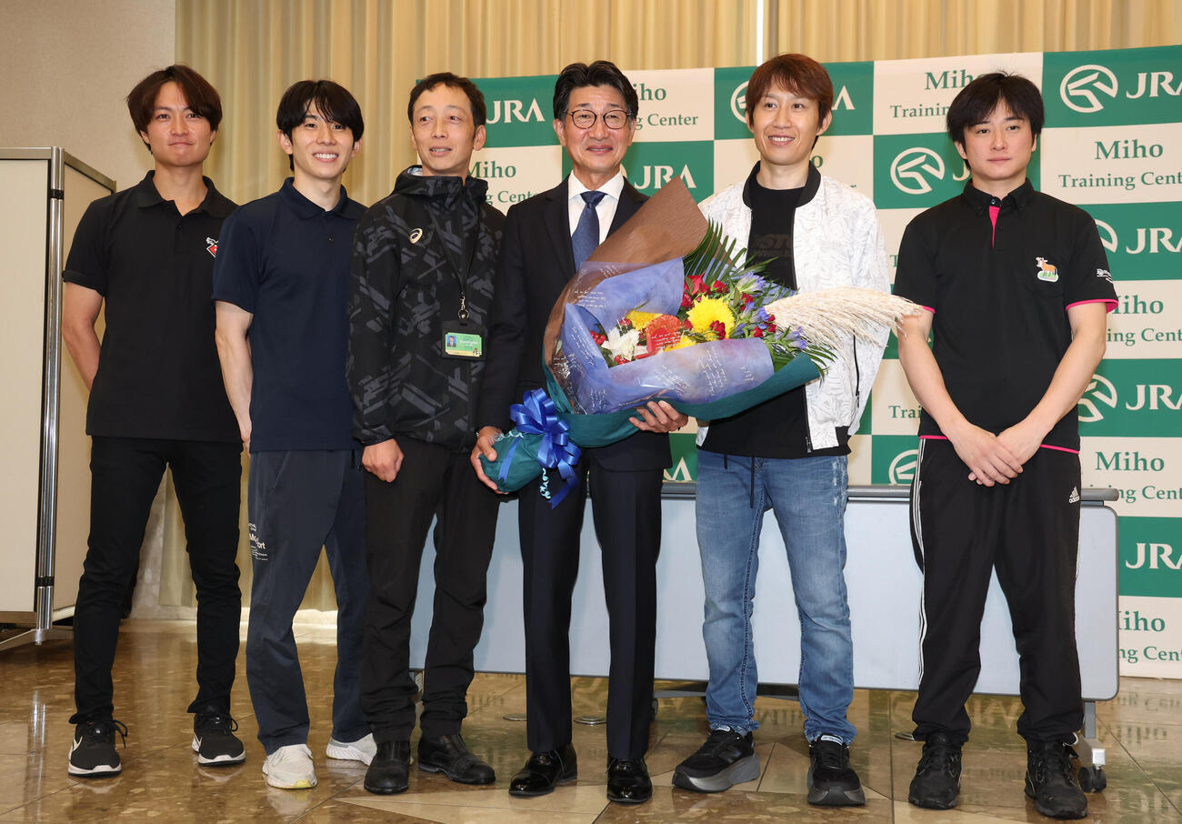 引退記者会見を終えて花束を手に写真に納まる柴田善臣騎手（左から4人目）（撮影・丹羽敏通）