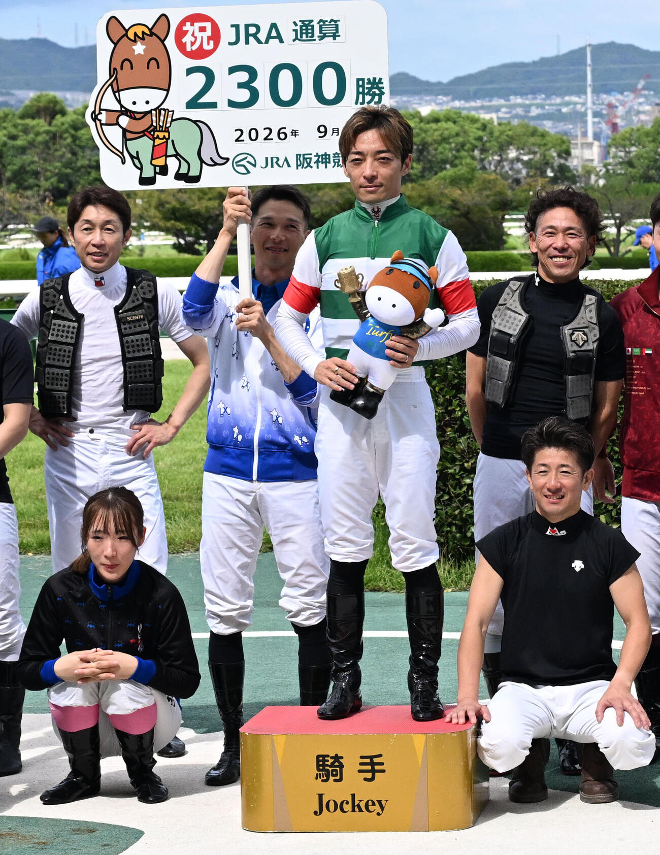 JRA通算2300勝を達成し、記念撮影をする川田将雅騎手（中央右）、武豊騎手（左上）（撮影・石井愛子）