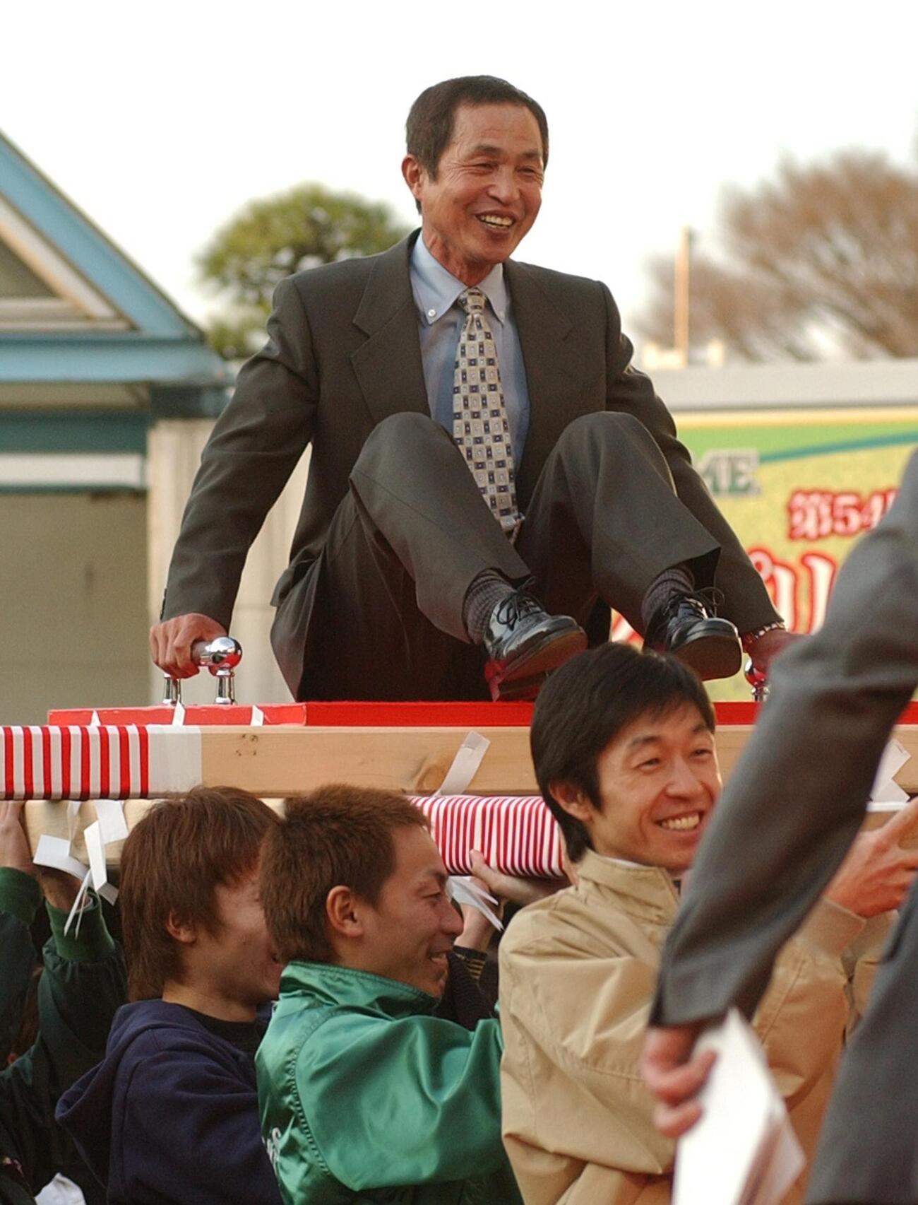 武豊騎手（右）らの担ぐおみこしに乗ってパドックを一周する岡部騎手（2005年撮影）