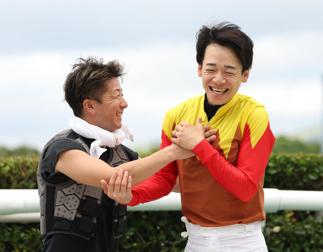 JRA年間100勝を達成し酒井学騎手（左）から手洗い祝福を受ける松山弘平騎手（撮影・白石智彦）
