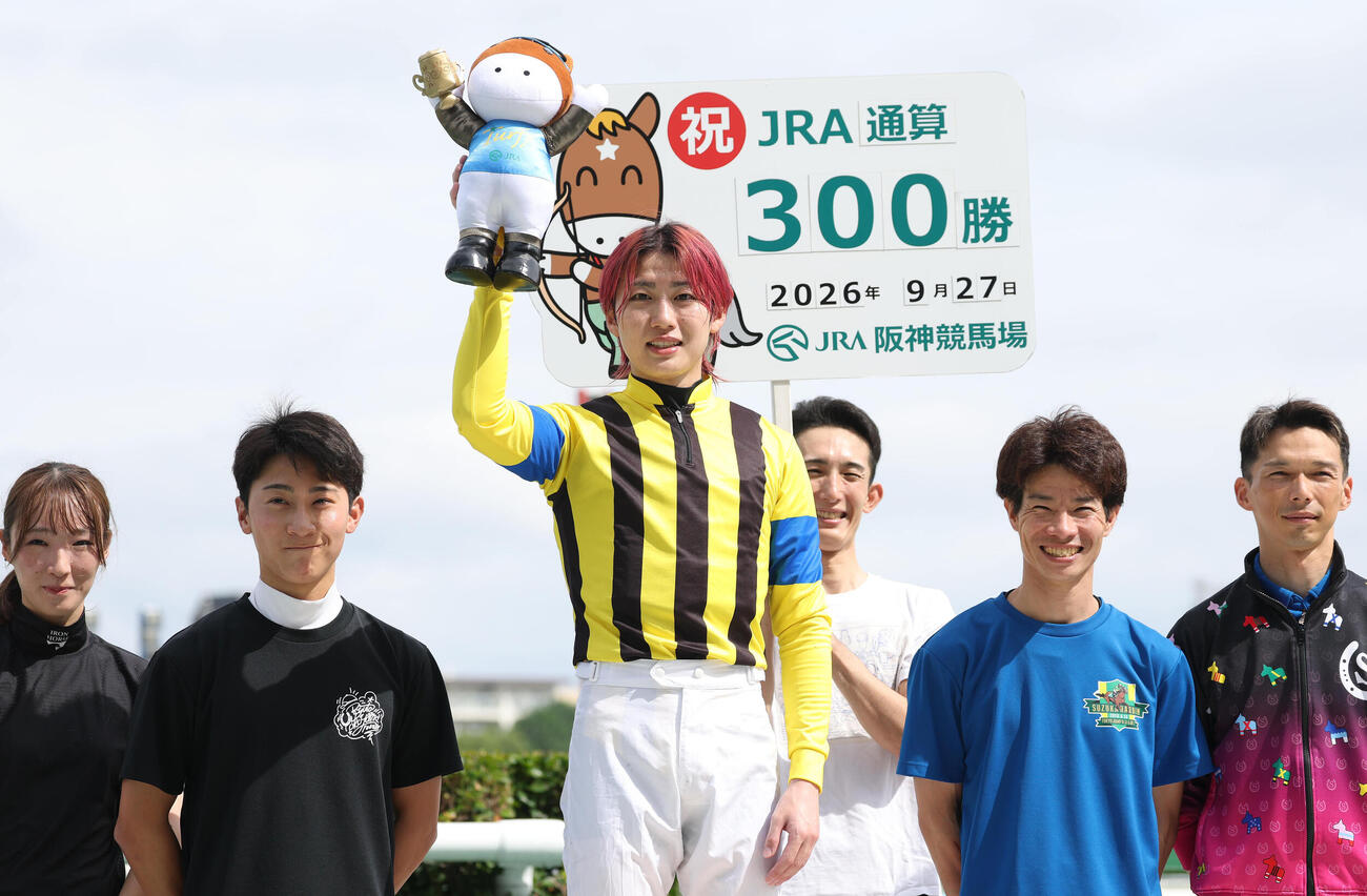 阪神2R、JRA通算300勝を達成しターフィー人形を掲げる斎藤新騎手（中央）（撮影・白石智彦）