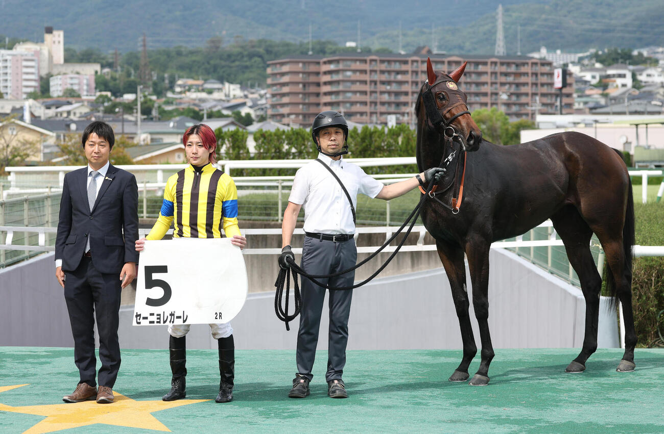 阪神2R、2歳未勝利を勝ち上ったセーニョレガーレと口取りに並ぶ斎藤新騎手（中央）（撮影・白石智彦）