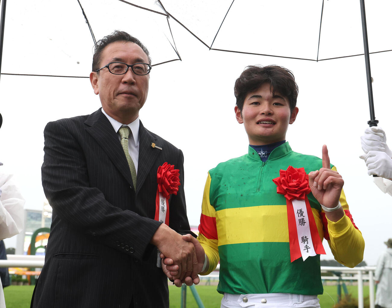 エコロディノスで京都大賞典を制した田口貫太騎手（右）は大久保龍志調教師と握手（撮影・白石智彦）